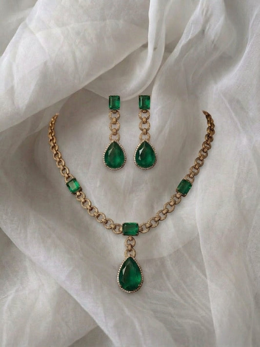 Gold chain link necklace with emerald cut stones.