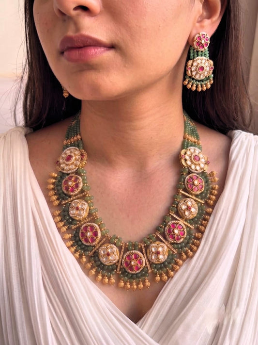 Kundan long necklace set with ruby stones and antique gold finish.
