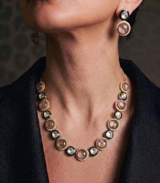 Lavanya gold kundan choker necklace 
with green enamel and mauve stones,
 matching stud earrings on white fabric