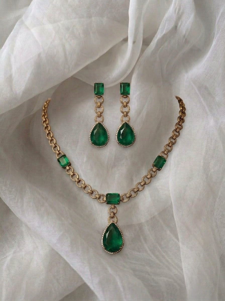 Gold chain link necklace with emerald cut stones.